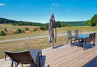 View from the terrace at Haus Wasser cabin in Germany with outdoor furniture and scenic hills.