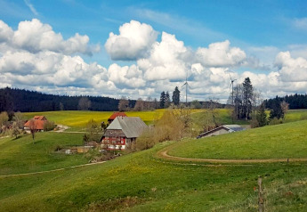 Landelijk uitzicht bij Haus Wasser in Duitsland met groene heuvels, boerderijen en windmolens aan de horizon.