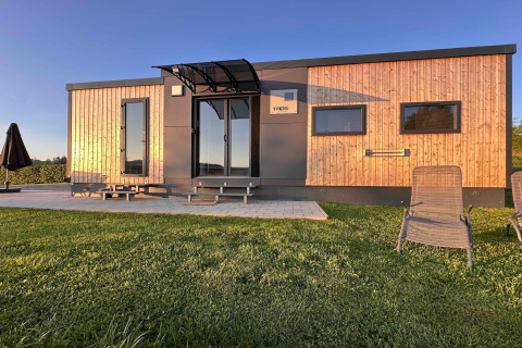 Tiny house moderna con rivestimento in legno al Holiday village SEEBLICK sul lago Eixendorfer.