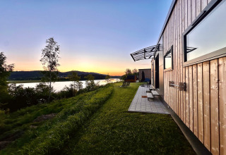 Tramonto presso Holiday village SEEBLICK - Tiny Chalet sul lago Eixendorfer, Germania, vista su lago e colline.
