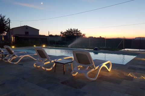Tramonto in piscina con lettini presso la tenda safari «Tenda 1» in Italia, atmosfera rilassante.