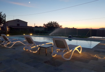 Zonsondergang bij het zwembad met ligstoelen bij safaritent «Tenda 1» in Italië, rustige sfeer.