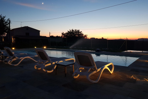 Zonsondergang bij het zwembad met ligstoelen bij safaritent «Tenda 1» in Italië, rustige sfeer.
