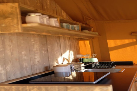 Rustieke keuken in safaritent Tenda 1 in Italië met houten planken, kookplaat, gootsteen en zonlicht