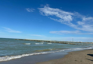 Uitzicht op zee en strand vanaf safaritent «Tenda 1» op een zonnige dag in Italië.