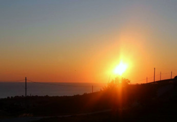Zonsondergang gezien vanaf safaritent Tenda 1 in Italië, met een rustige horizon en gouden zonlicht.