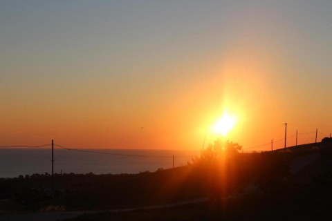 Zonsondergang gezien vanaf safaritent Tenda 1 in Italië, met een rustige horizon en gouden zonlicht.
