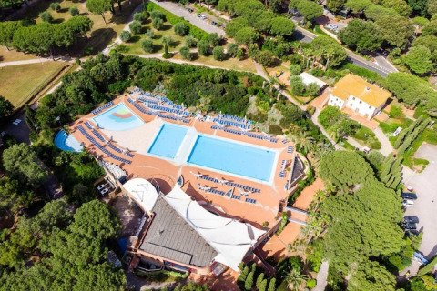 Vista aérea del Holiday Resort Riva degli Etruschi en Italia, con piscinas y tumbonas rodeadas de árboles.