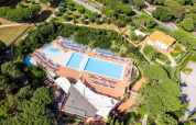 Aerial view of Holiday Resort Riva degli Etruschi in Italy, featuring pools and sun loungers among trees.