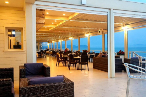Terraza amplia de mobil home frente al mar, con muebles cómodos y cálida iluminación ambiental.