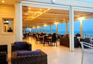 Spacious mobile home terrace with sea view, comfortable outdoor seating, and cozy ambient lighting.