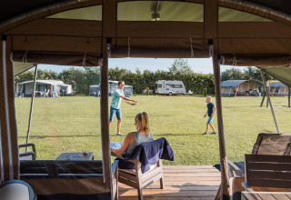 Udsigt fra safari telt på Camping Nommerlayen 2 i Luxembourg, med familie der slapper af og leger.