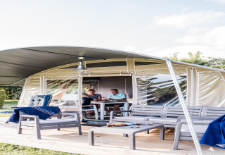 Safari teltet Camping Nommerlayen 2 i Luxembourg med to personer, udendørs møbler og afslappet stemning.