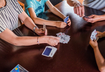 Gezin speelt samen een kaartspel in een safaritent op Resort Nommerlayen 3 in Luxemburg.