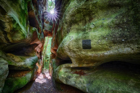 Zonnestralen schijnen door een kloof bij Resort «Auf Kengert 1» in Luxemburg.