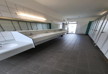 Foto di un moderno bagno condiviso in tenda safari con lavandini, specchi e cabine chiuse.
