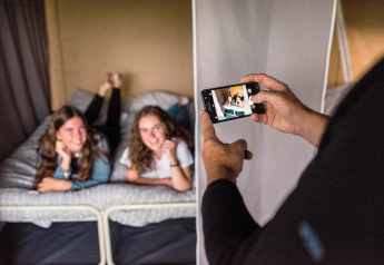 Deux jeunes femmes posent sur un lit pendant qu'une personne les photographie dans une tente safari au Luxembourg.