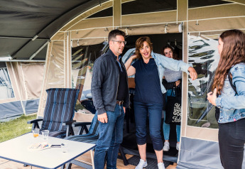 Un groupe de personnes profite de leur séjour devant une tente safari Camping Gritt 1 au Luxembourg.