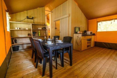 Interno di una tenda safari di lusso ad Ameland nei Paesi Bassi, con sala da pranzo e cucina.