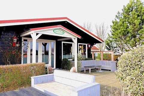 Udendørs område ved A.G.'s Pub ved luksussafari-telt 'on Ameland', omgivet af planter i Holland.