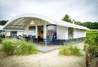 Tienda safari en Recreation Park Duinhoeve 7 con terraza cubierta, arena y vegetación alrededor del alojamiento.