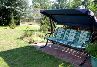 Tuinzetel met bloemmotief en blauwe luifel bij de chalet ‘By Ostseebad Rerik’, Duitsland.