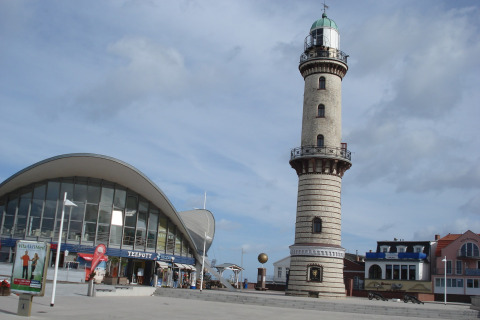 Foto del faro e edificio moderno sul lungomare di Ostseebad Rerik, Germania, in una giornata di sole.