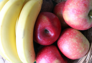Un cesto con banane mature e mele rosse, fotografato in una baita vicino a Ostseebad Rerik, Germania.