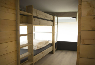 Wooden bunk bed inside a modern safari tent at Recreation Park Duinhoeve in the Netherlands, interior view.