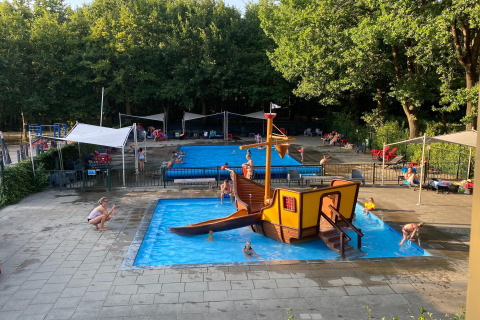 Outdoor children’s pool with a pirate ship play structure at Recreation park Duinhoeve in the Netherlands.