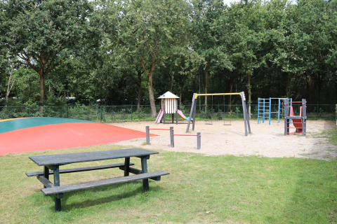 Aire de jeux avec balançoires, toboggan, structure d’escalade et table à Duinhoeve 7, Pays-Bas.