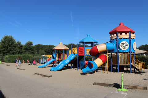 Parque infantil colorido con toboganes y torres en un día soleado en Recreation park Duinhoeve 7, Países Bajos.