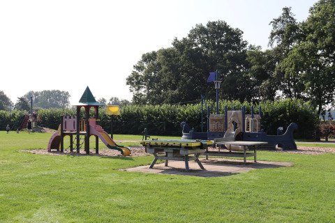 Parque infantil con toboganes y juegos sobre césped en el Recreation Park Duinhoeve 7, Países Bajos.