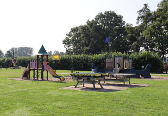 Parque infantil con toboganes y juegos sobre césped en el Recreation Park Duinhoeve 7, Países Bajos.