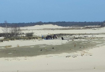 Vista de dunas de arena con un grupo de personas y caballos en Recreation Park Duinhoeve 7, Países Bajos.