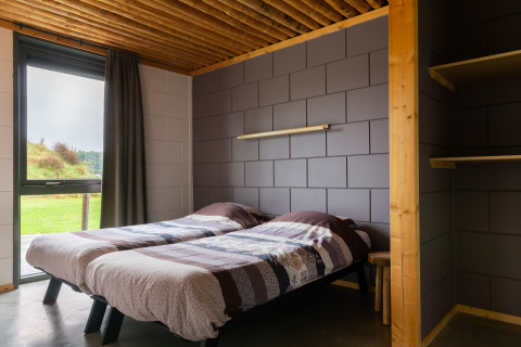 Camera moderna al lodge Koe in de Kost 3 nei Paesi Bassi con due letti singoli e vista sul verde.