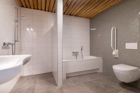 Toegankelijke badkamer met modern ontwerp, ligbad, douche en beugel bij Koe in de Kost 4, Nederland.
