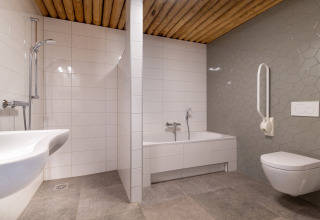 Toegankelijke badkamer met modern ontwerp, ligbad, douche en beugel bij Koe in de Kost 4, Nederland.