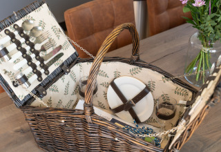 A beautifully arranged picnic basket with plates, cutlery, and glasses at 't Landgoed Baars 1, Netherlands.