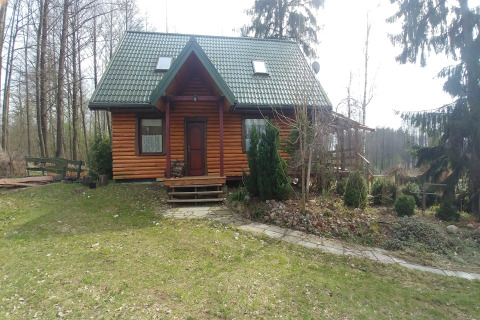 Chalet en bois House Gajewo à Podlasie, entouré d’arbres et de verdure dans un cadre paisible.