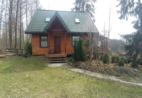 Chalet en bois House Gajewo à Podlasie, entouré d’arbres et de verdure dans un cadre paisible.