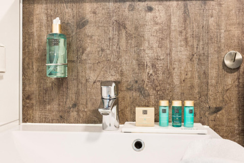 Badkamer met Rituals producten, kraan en houten wand bij Residence De Eese 3 in Nederland.