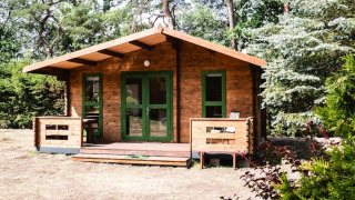 Nature house Holiday homes Kodrabek-35 sqm, wooden cabin surrounded by lush trees and greenery.