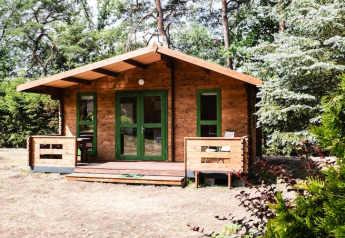 Holzferienhaus Kodrabek-35 qm inmitten der Natur, umgeben von grünen Bäumen und Sträuchern.