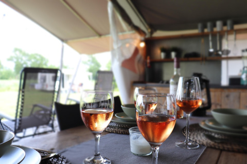 Table dressée avec verres de vin dans la tente safari «Noflik» aux Pays-Bas, ambiance conviviale.
