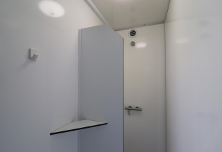 Photo d’une salle de bain minimaliste et moderne dans un hébergement glamping, murs blancs et ventilation.