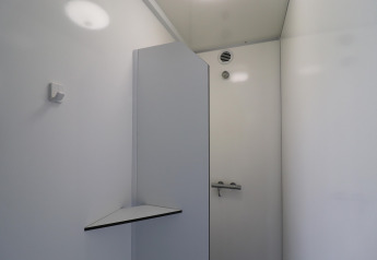 Foto af et moderne og minimalistisk badeværelse i et glamping-ophold med lyse hvide vægge og en ventil.