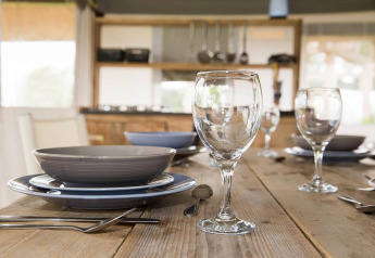 Borddækning med tallerkener, glas og bestik i et safaritelt ved Safari tent 'Noflik' i Holland.