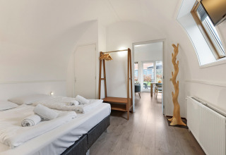 Dormitorio moderno y luminoso en Water park De Bloemert 6, Países Bajos, con cama doble y decoración de madera.
