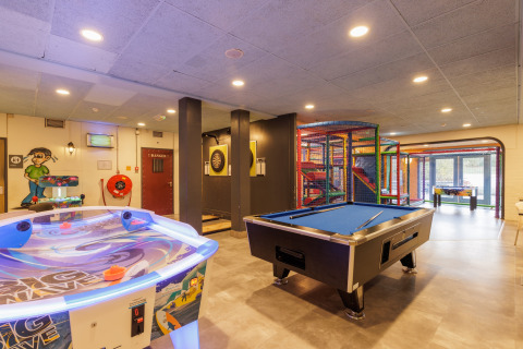 Sala de juegos interior en una tienda safari con billar, hockey de aire, diana y zona infantil.